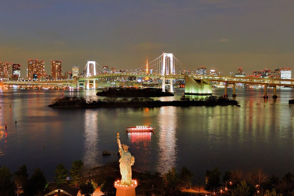 Odaiba Statue of Liberty in the Tokyo Bay, with the Tokyo rainbow bridge behind