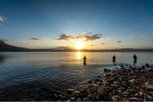 Lake Towada at sunrise with 3 people fishing