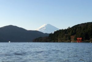 Lake Ashinoko in Kanagawa Prefecture, with a snow capped Mount Fuji Behind and the Torii of Hakone Shrine on the lake's edge