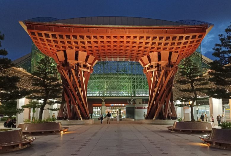Kanazawa Station at night, a large wooden torii gate structure outside Kanazawa Station illuminated at night.