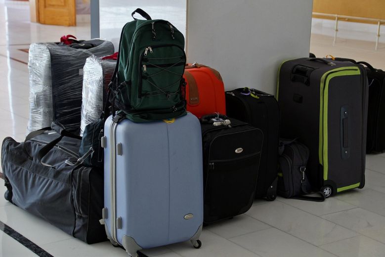 a pile of suitcases, where to store luggage in Japan