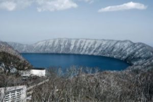 Lake Kuttara in Hokkaido, near Noboribetsu. Winter scene, mountains covered in snow, blue lake.