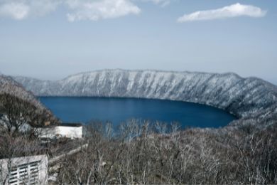 Lake Kuttara in Hokkaido, near Noboribetsu. Winter scene, mountains covered in snow, blue lake.