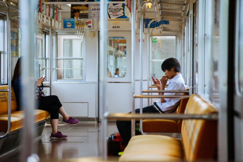 A quiet Japanese train interior with two passengers