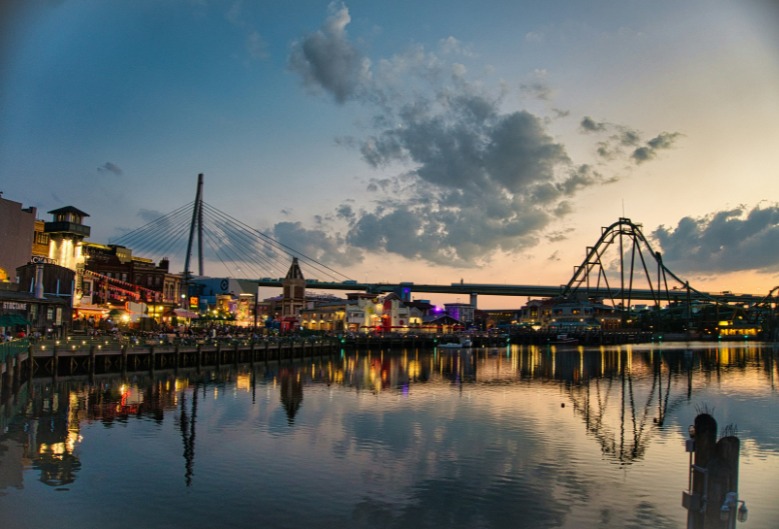 Universal Studios Japan, or USJ, at sunset, rollercoaster and lake shown in the background