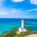 A white lighthouse with a vibrant blue sea at Cape Hirakubozaki on Ishigaki Island