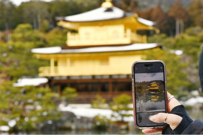 Kinkaku-ji, with a phone screen, showcasing the temple. Best Japan eSIM